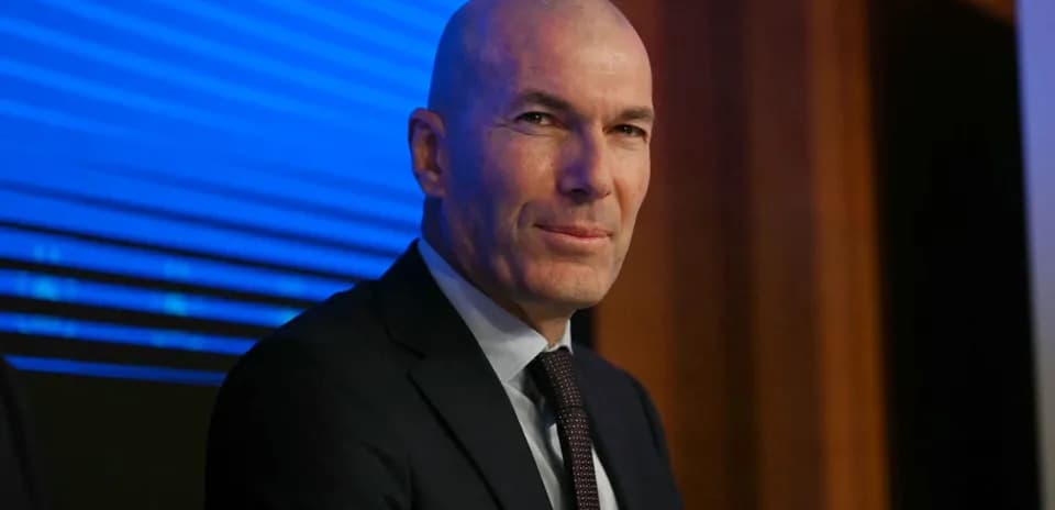 Man in suit sitting at press conference table