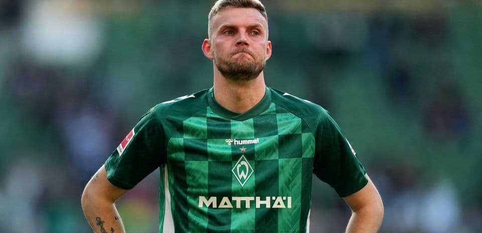 Player in green jersey looking concerned on the field