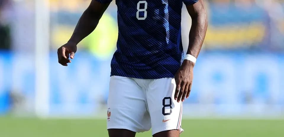 Player in France kit with ball on pitch