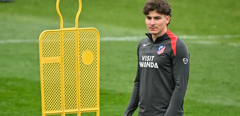 Player in training gear next to a training dummy