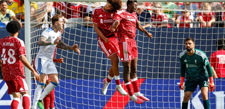 Two Liverpool players heading the ball in goal area