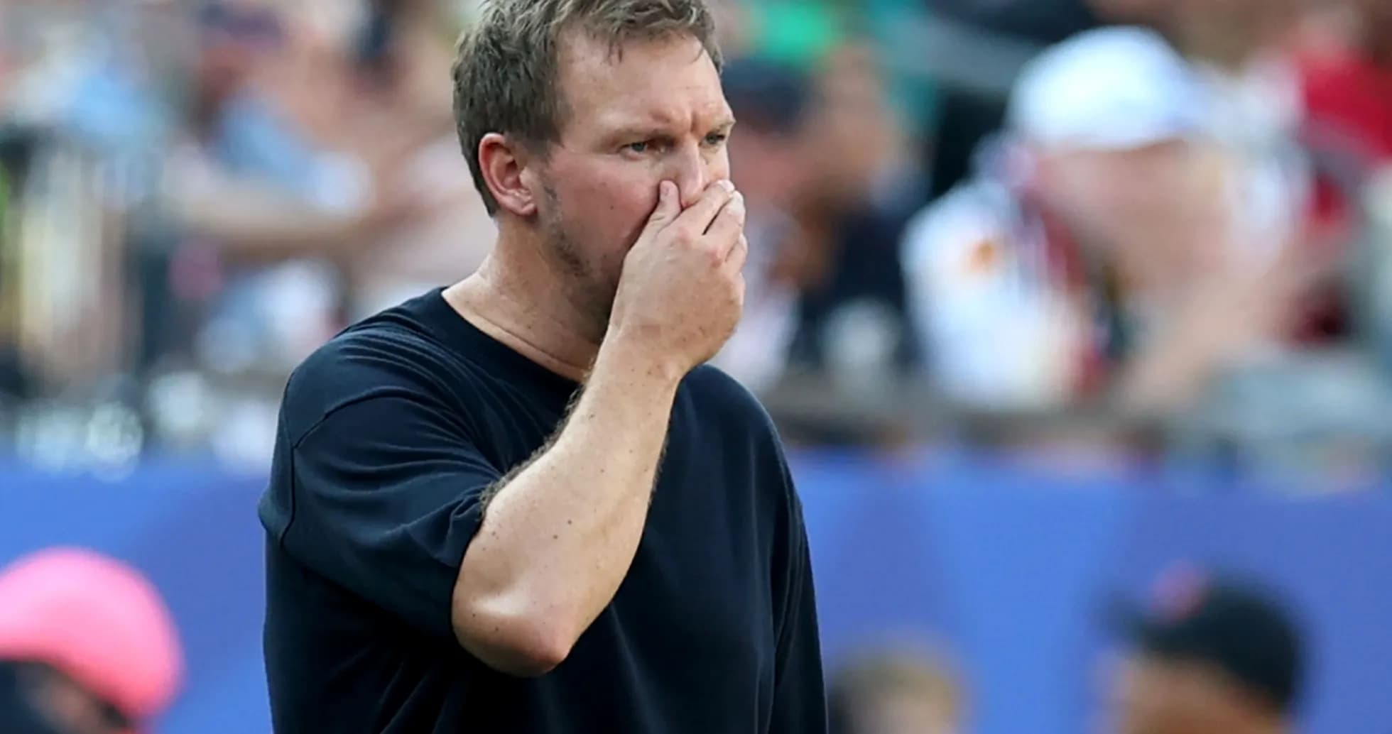 Coach observing the game with hand on face