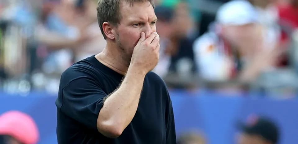 Coach observing the game with hand on face