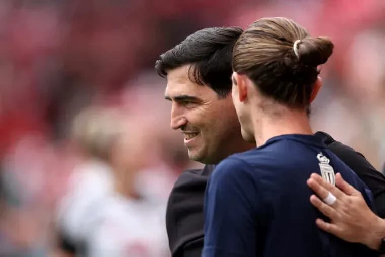 Coach and player embracing on the field
