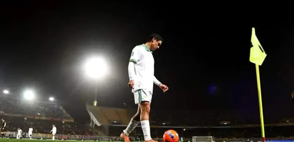 Player preparing to take a corner kick at night