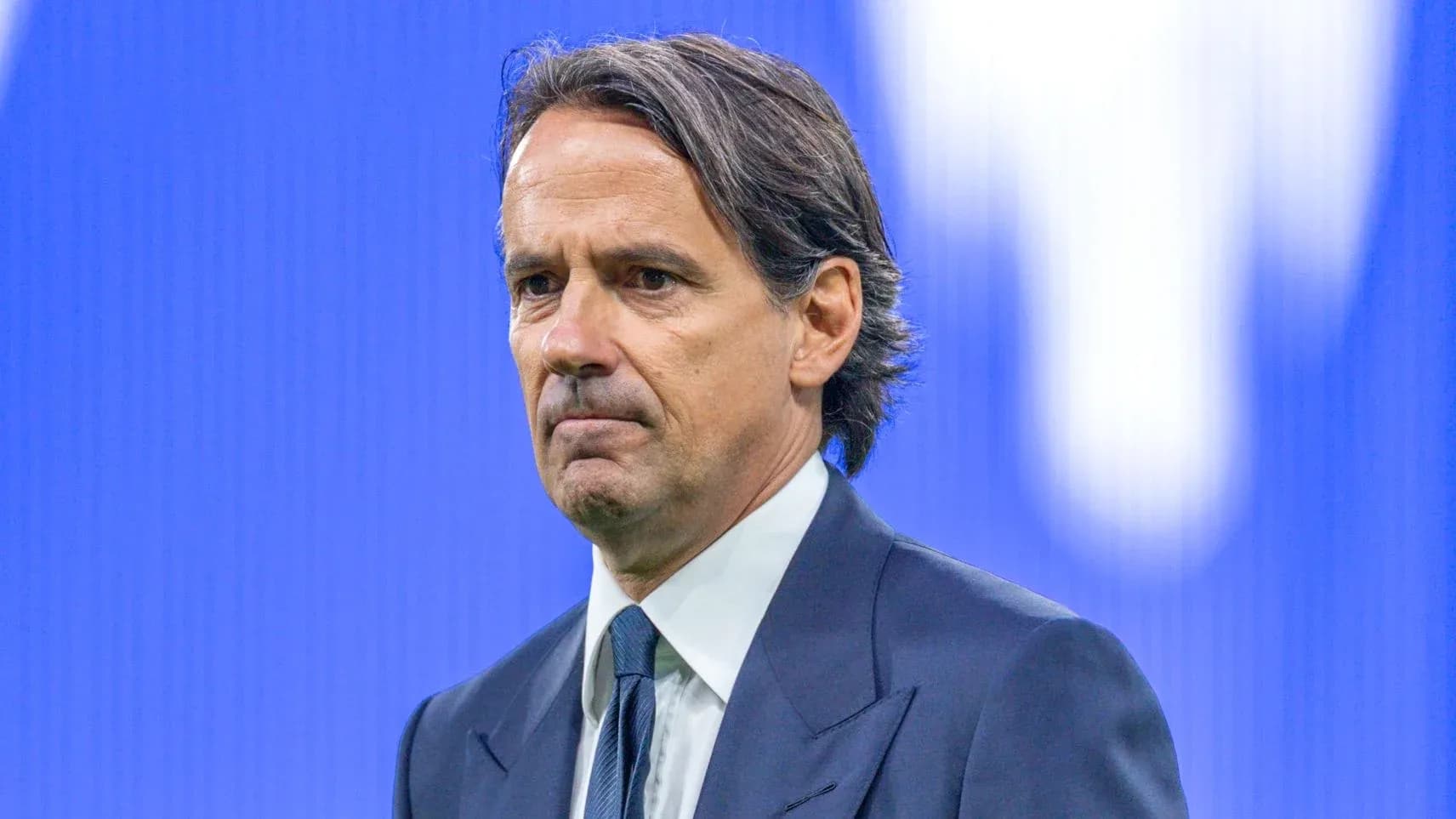Coach standing during a press conference backdrop