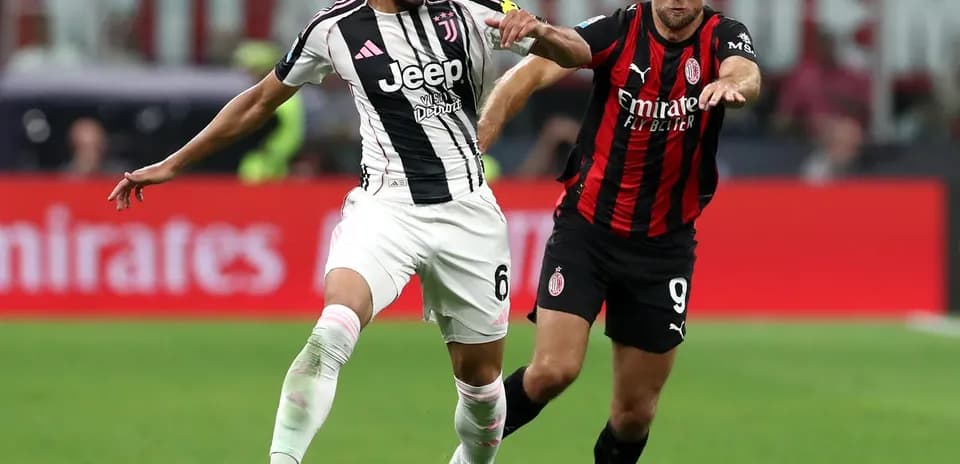 Juventus player dribbling past AC Milan opponent