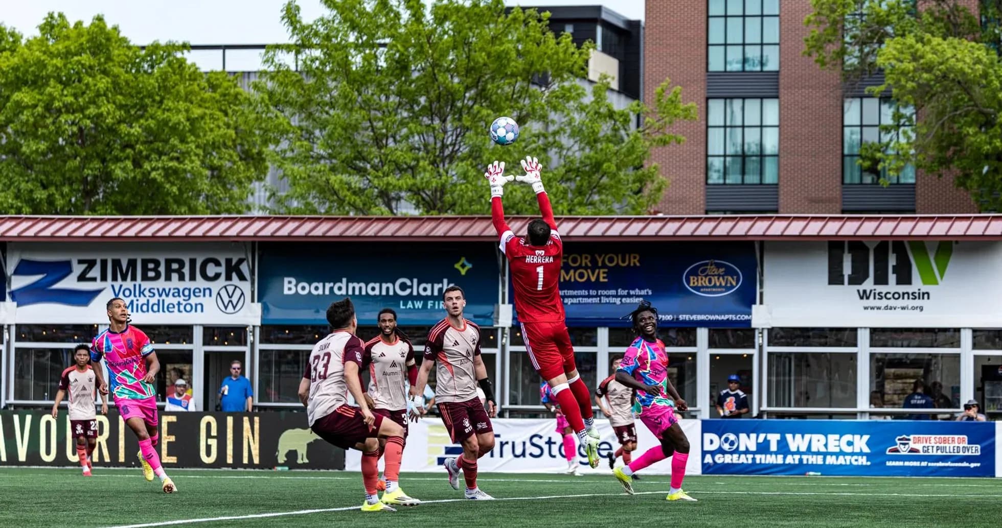 Goalkeeper jumping to catch the ball during match