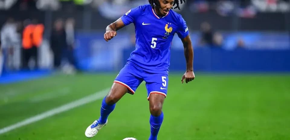 Player in blue kit dribbling soccer ball on field
