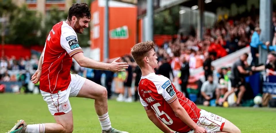 Two players celebrating a goal on the field