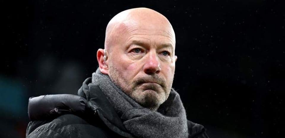 Man in a black coat and scarf at match