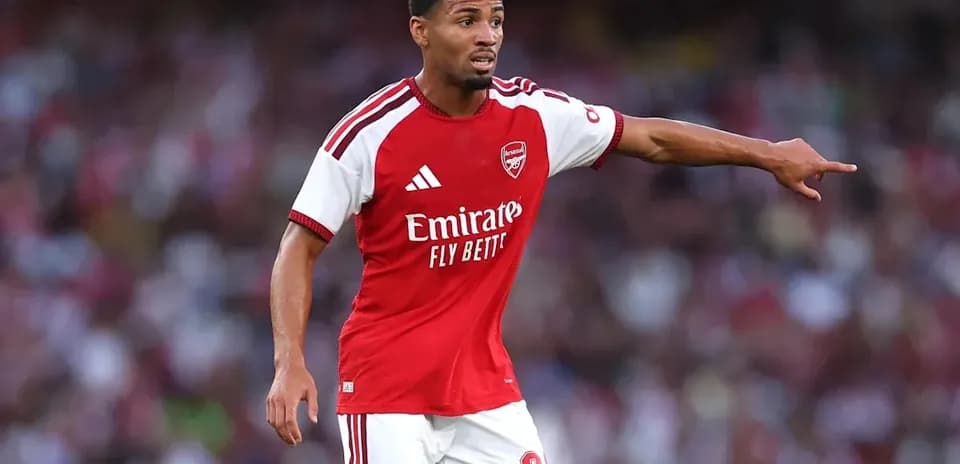 Player in Arsenal kit directing teammates on field