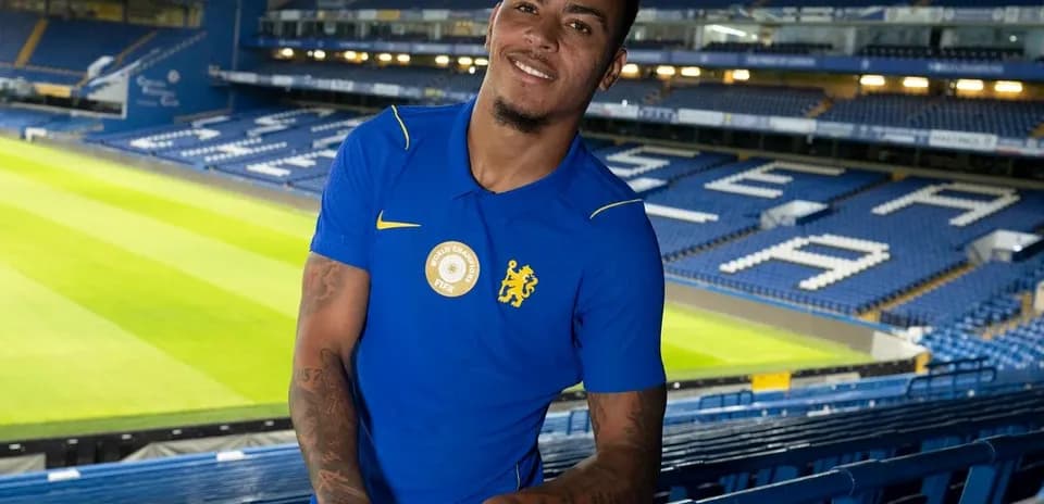 Player posing in Chelsea stadium stands