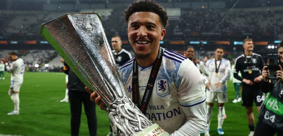 Player celebrating with UEFA trophy on field