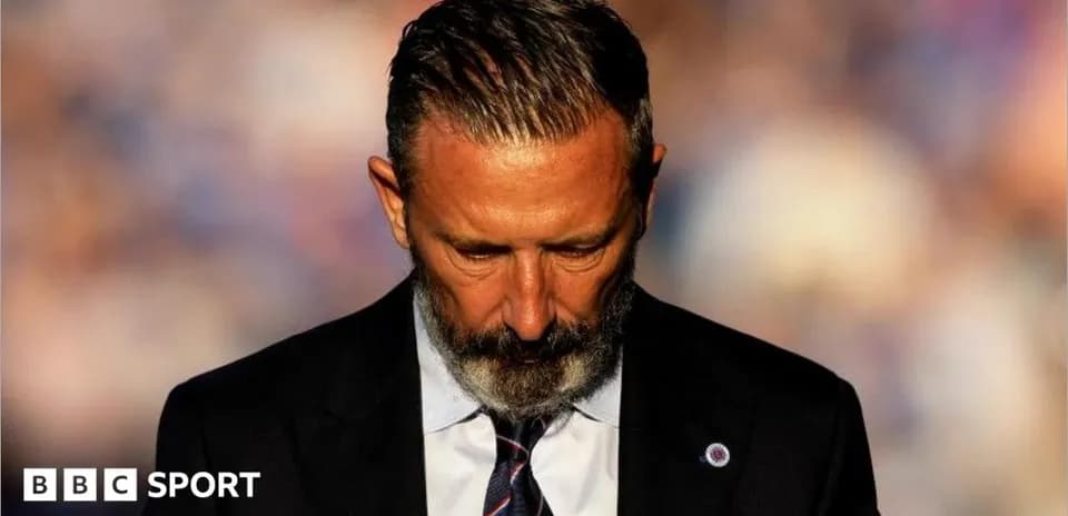 Man in suit looking down with serious expression