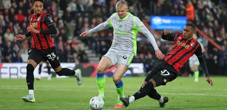 Erling Haaland dribbling between Bournemouth players