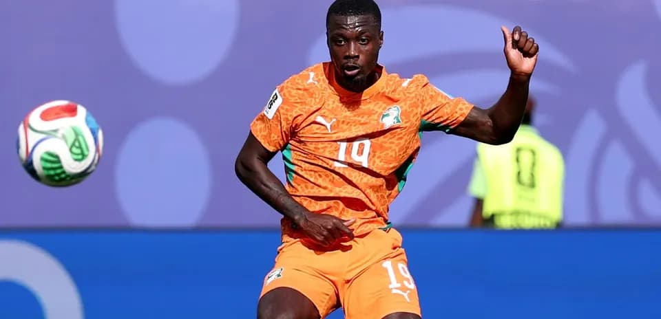 Player in orange jersey controlling a soccer ball