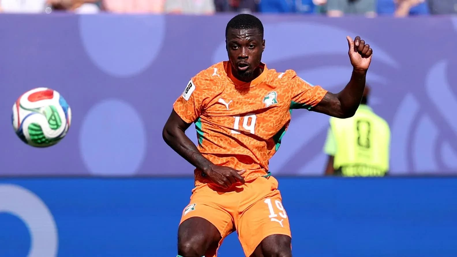 Player in orange jersey controlling a soccer ball