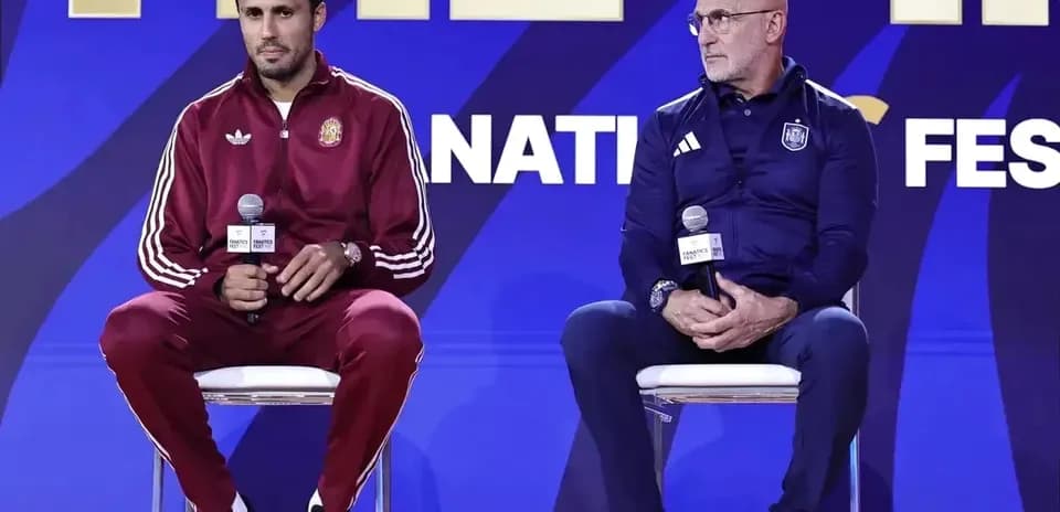 Two coaches seated at press conference podium