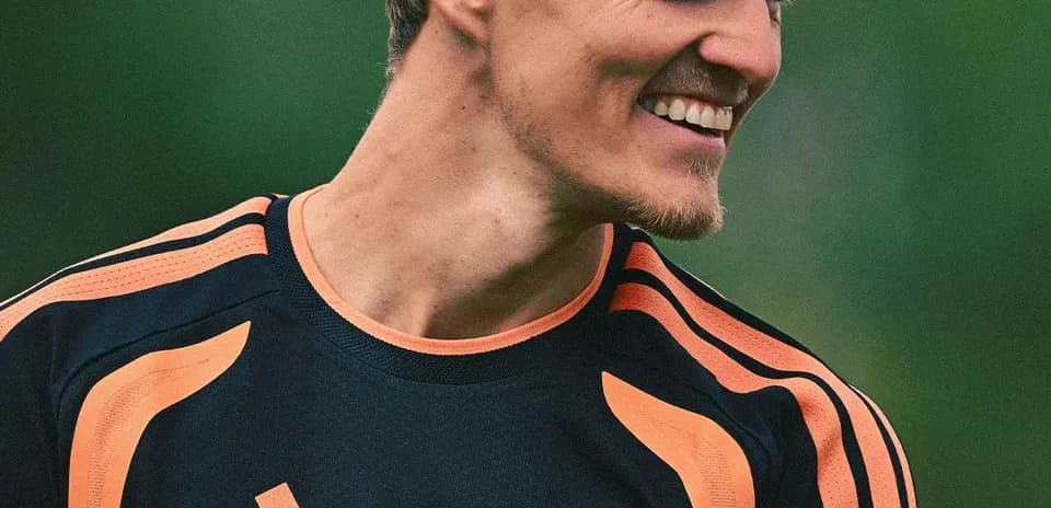 Player smiling in Arsenal training kit outdoors