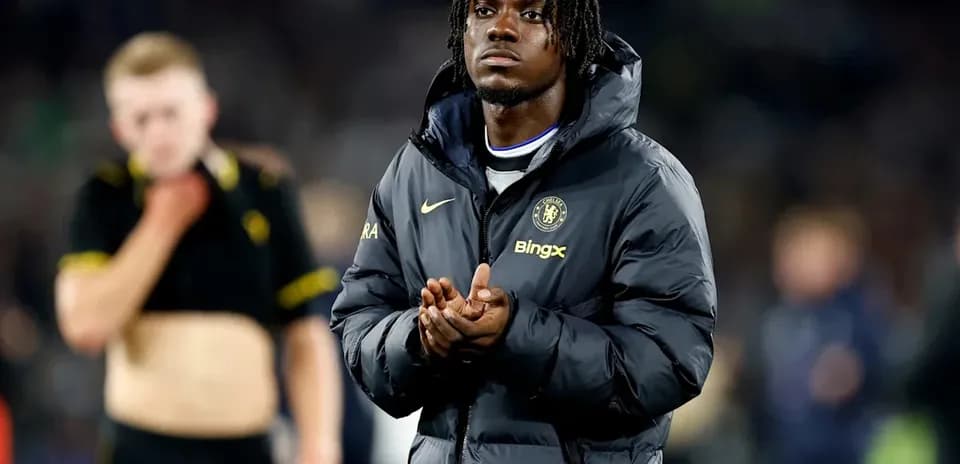 Chelsea player in jacket clapping after match