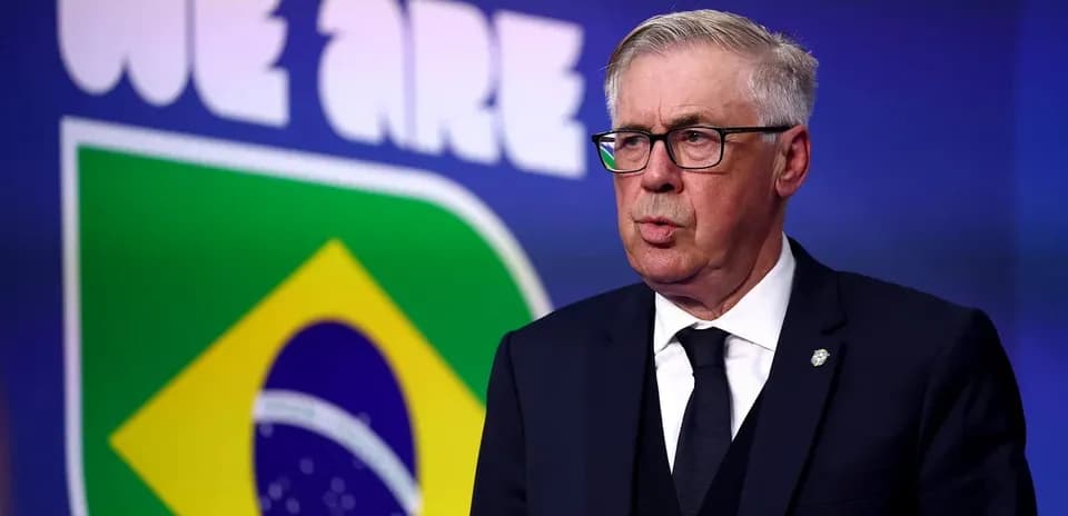 Coach speaking at press conference with Brazil logo backdrop