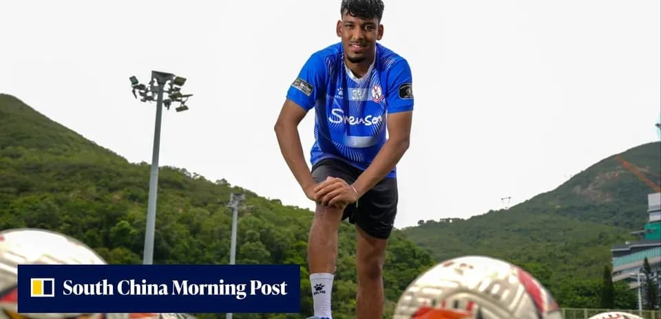 Player posing with footballs on training ground
