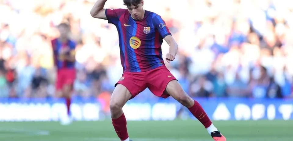 Player in Barcelona kit dribbling the ball on pitch