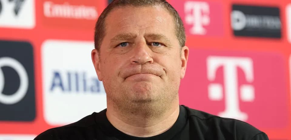 Manager at press conference with sponsor logos in background