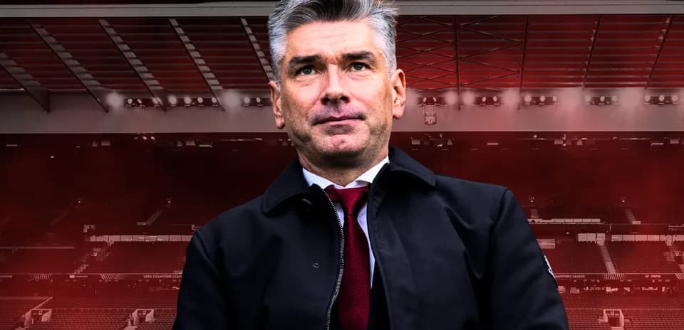 Coach standing in front of a stadium backdrop