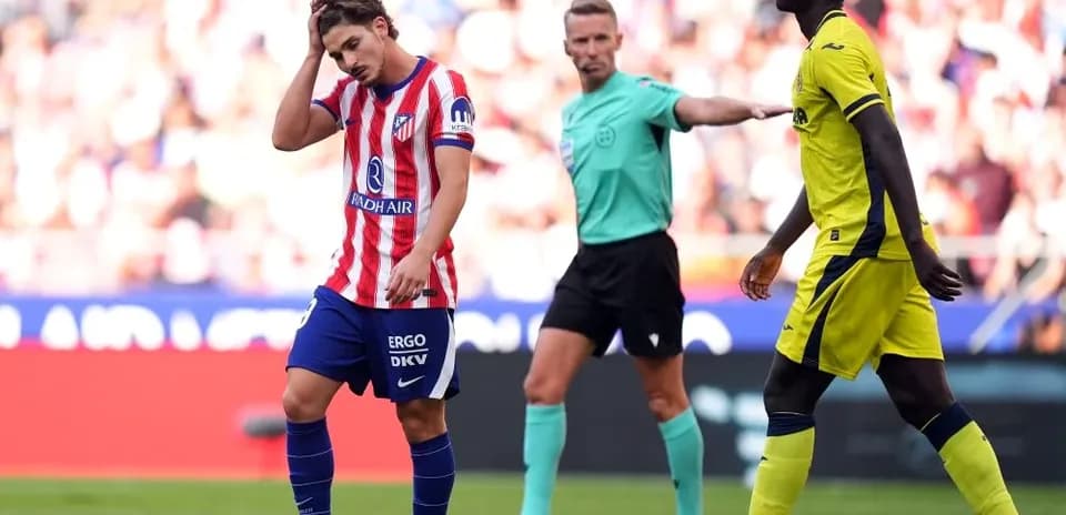 Atletico player reacting to referee's decision during match