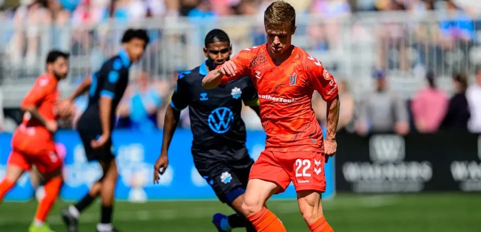 Player in orange jersey dribbling the ball