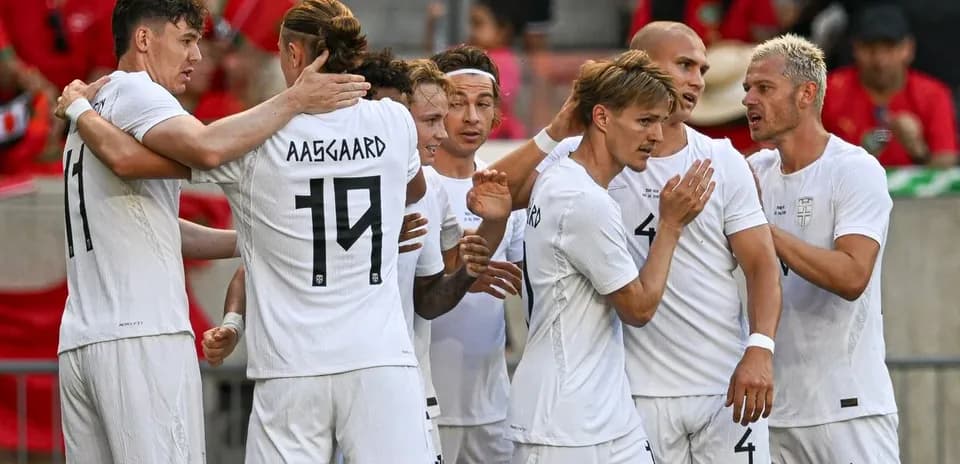Players celebrating a goal in white jerseys