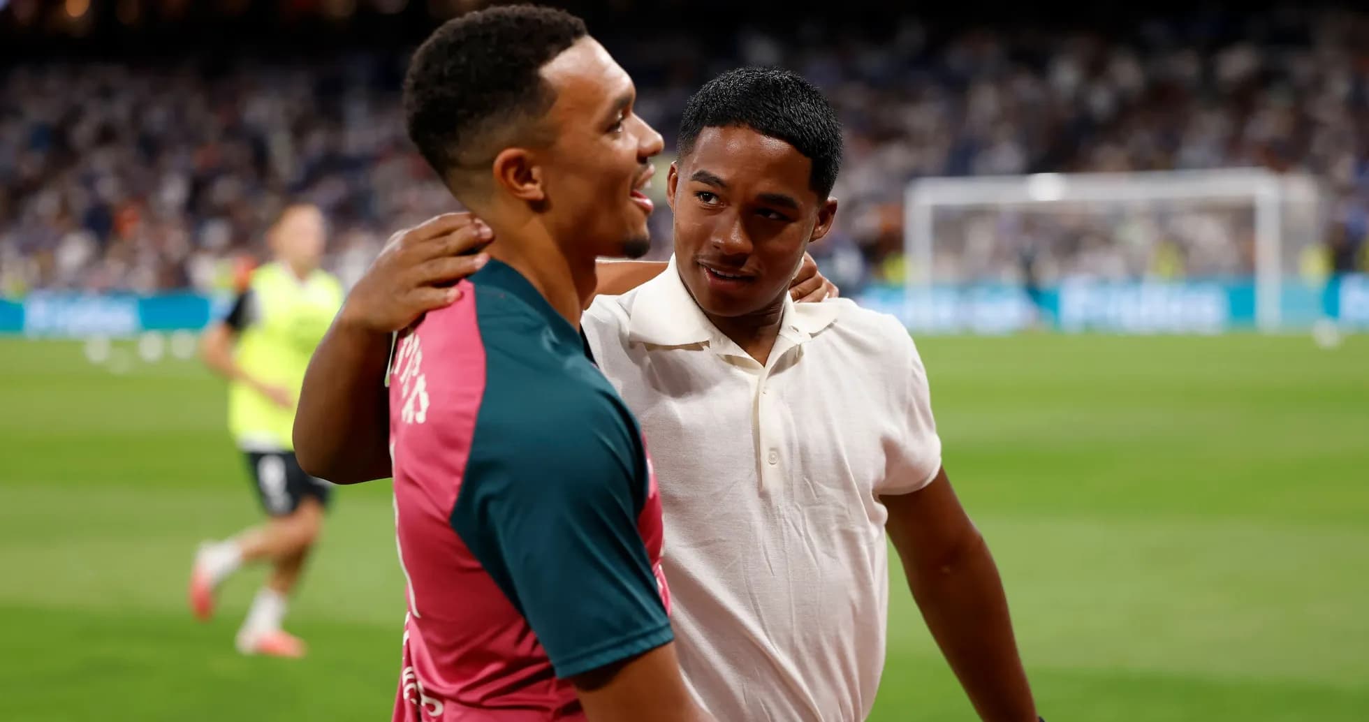 Two individuals embracing on the football pitch