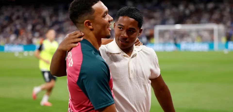 Two individuals embracing on the football pitch