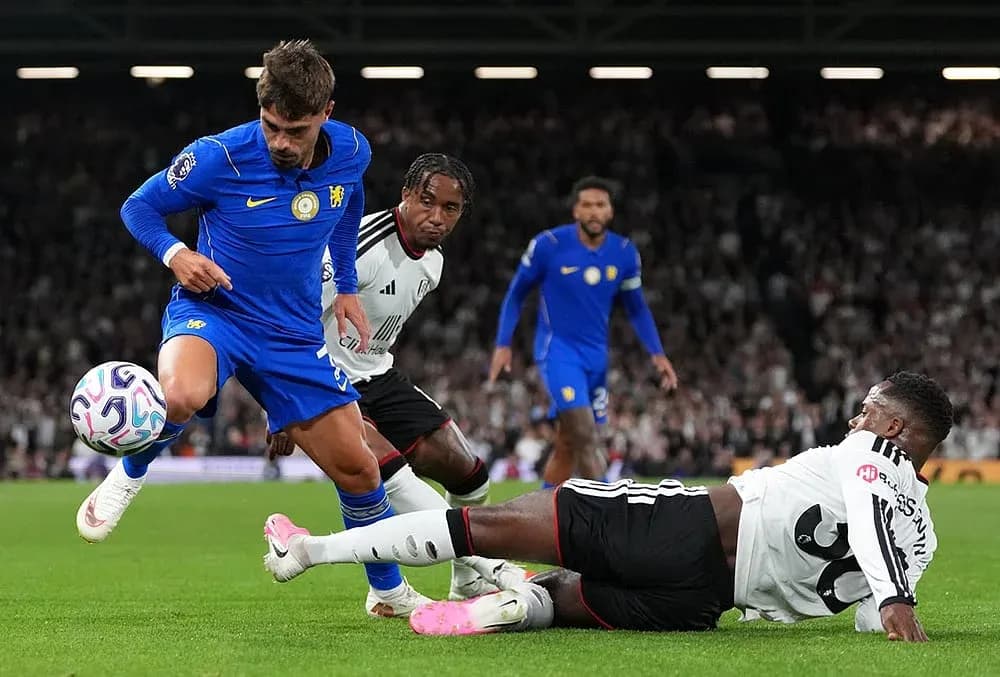Chelsea player dribbling past Fulham defenders