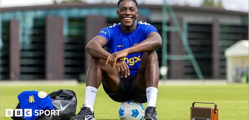 Player sitting on field with soccer ball and gear