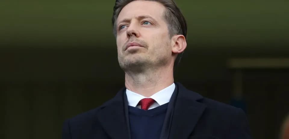 Man in a suit observing from the stands