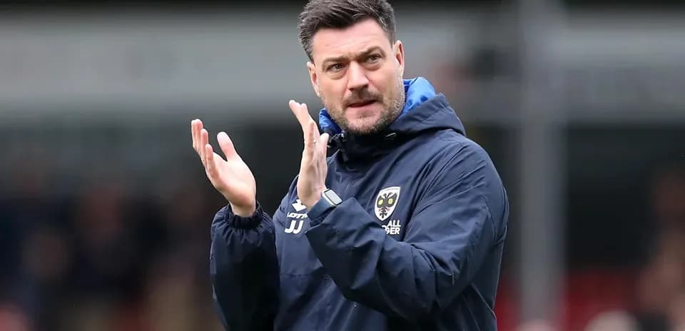 Coach applauding during a match on the sidelines