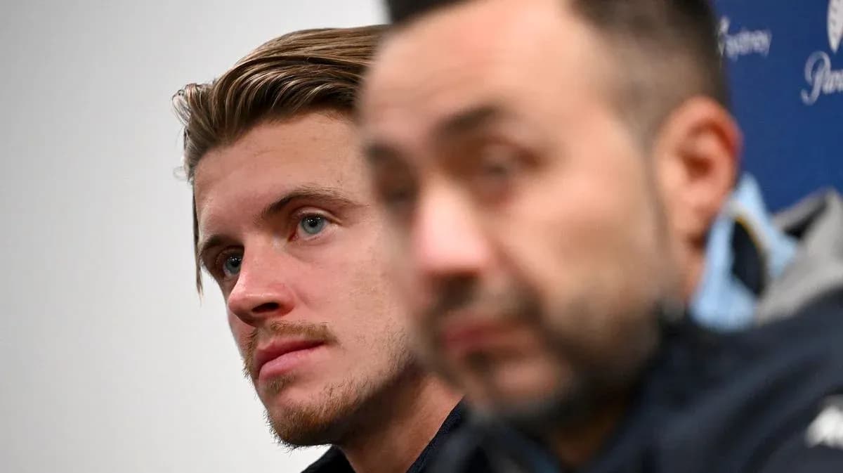Two individuals at a press conference, one in focus Two individuals at a press conference, one in focus