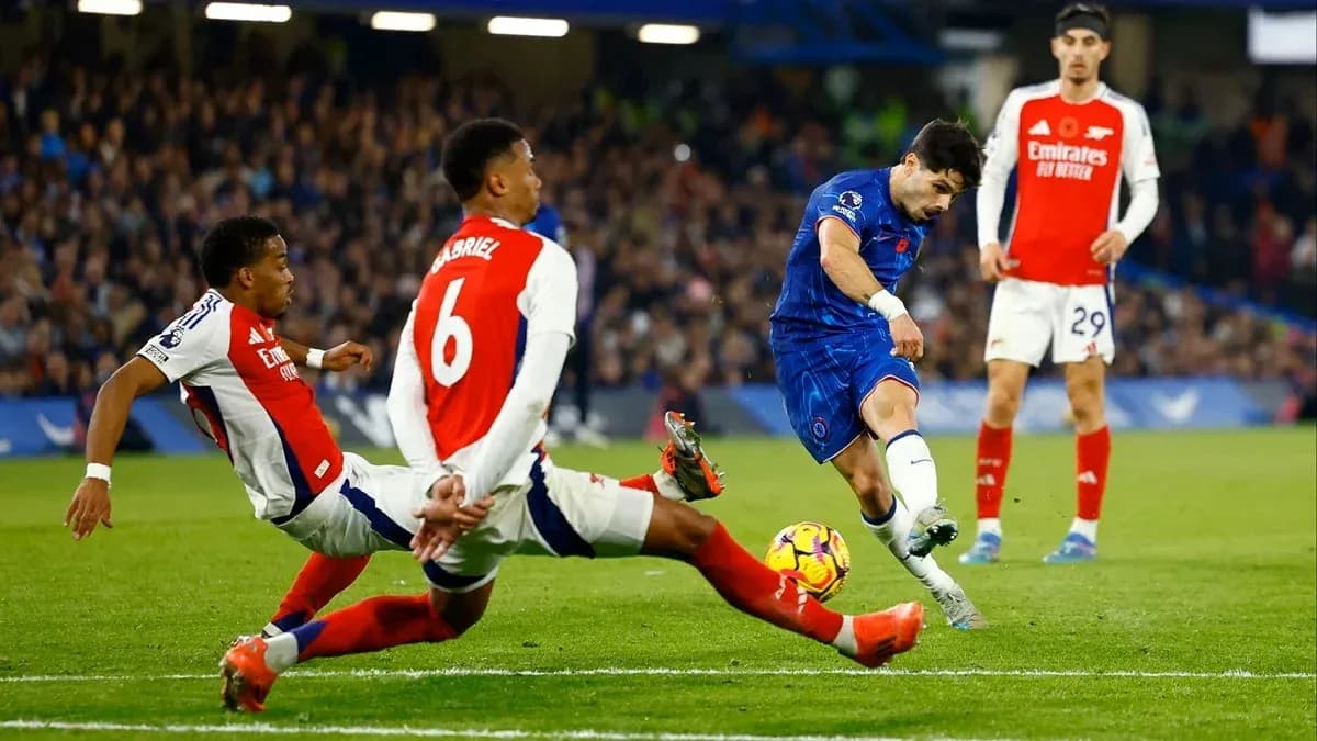 Chelsea player shooting past two Arsenal defenders Chelsea player shooting past two Arsenal defenders