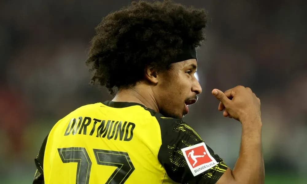 Player in Borussia Dortmund jersey celebrating on field Player in Borussia Dortmund jersey celebrating on field