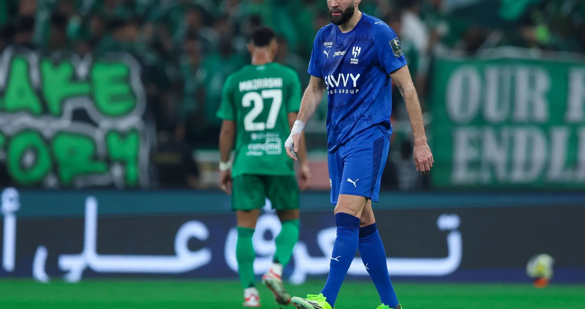 Player in blue jersey walking on pitch during match Player in blue jersey walking on pitch during match