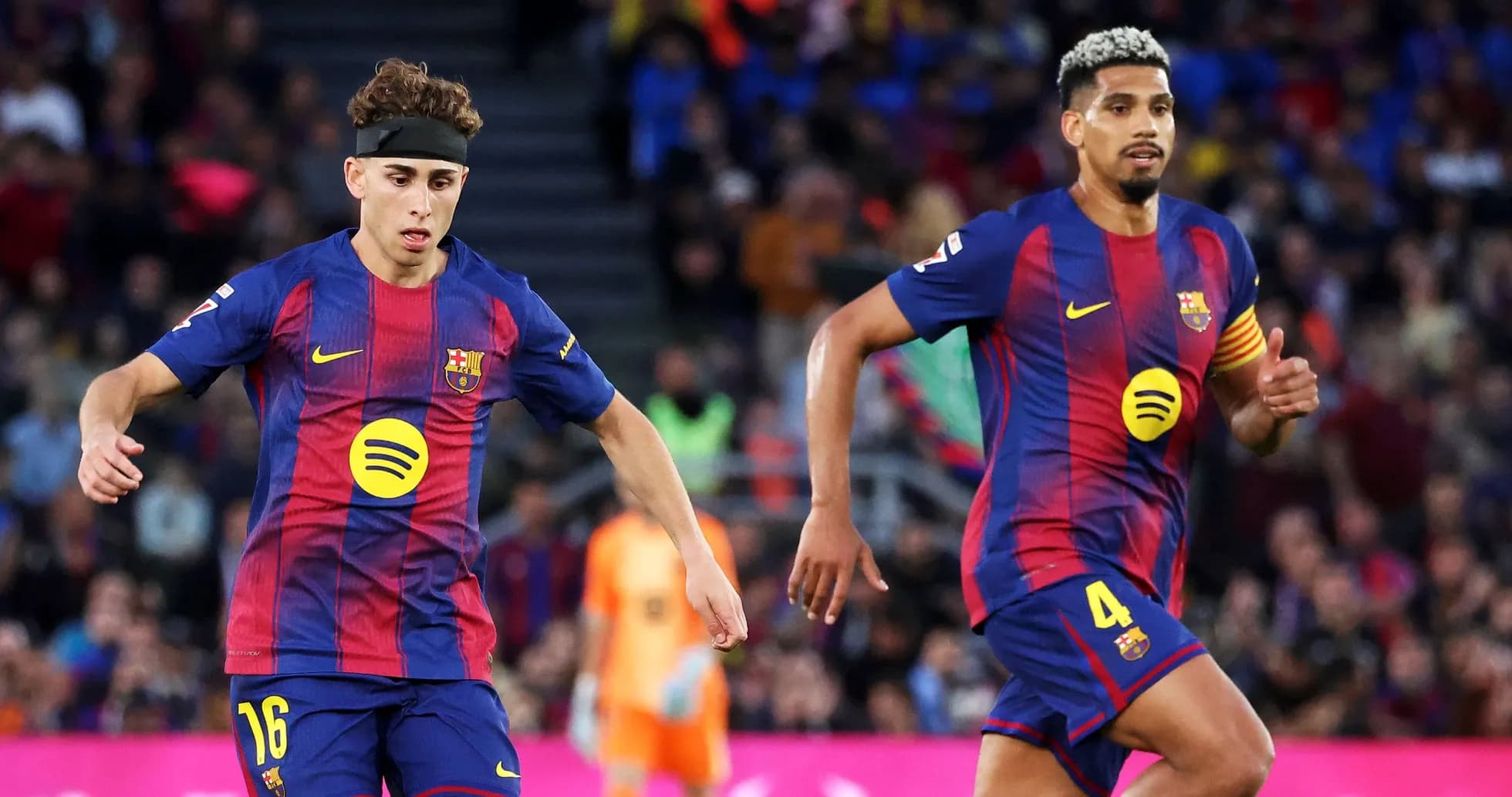 Two FC Barcelona players running on the field Two FC Barcelona players running on the field