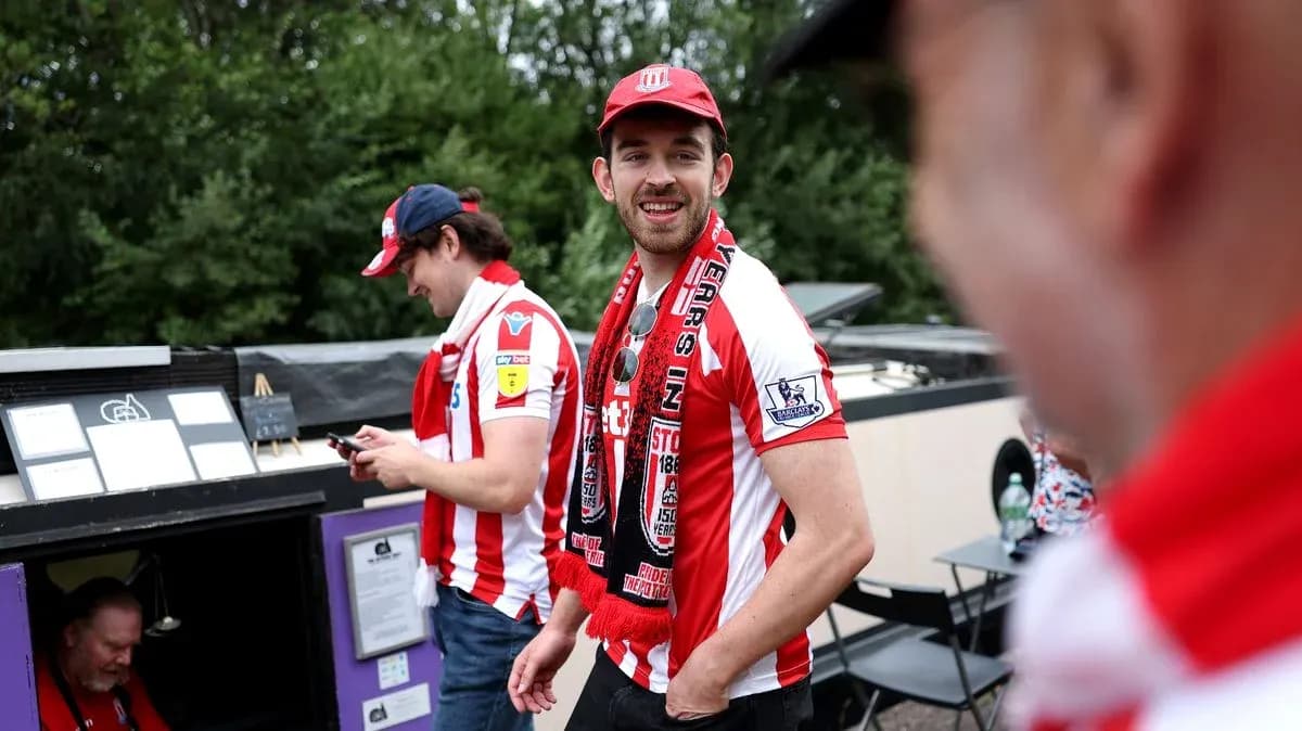 Fans wearing team jerseys and scarves outside venue Fans wearing team jerseys and scarves outside venue