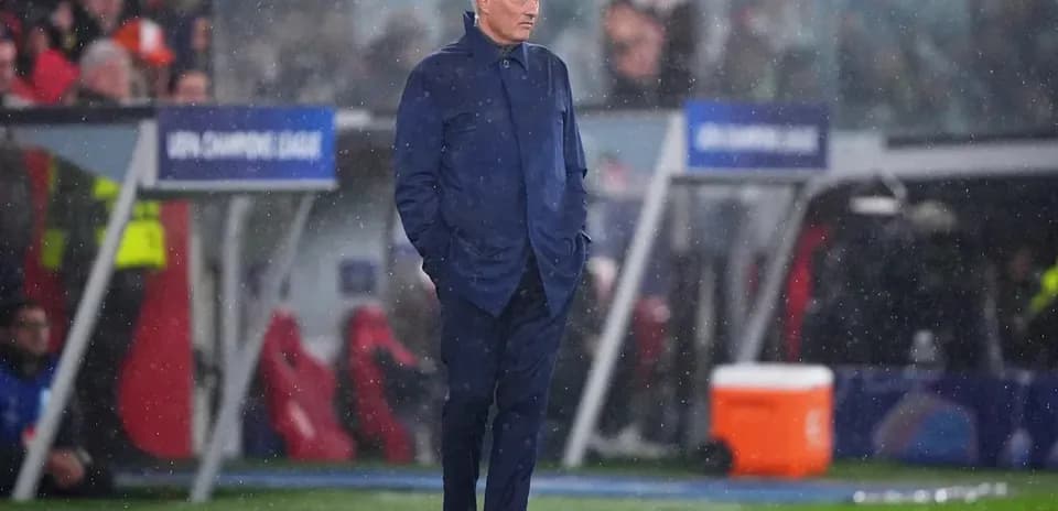 Manager standing on sideline during rainy match Manager standing on sideline during rainy match