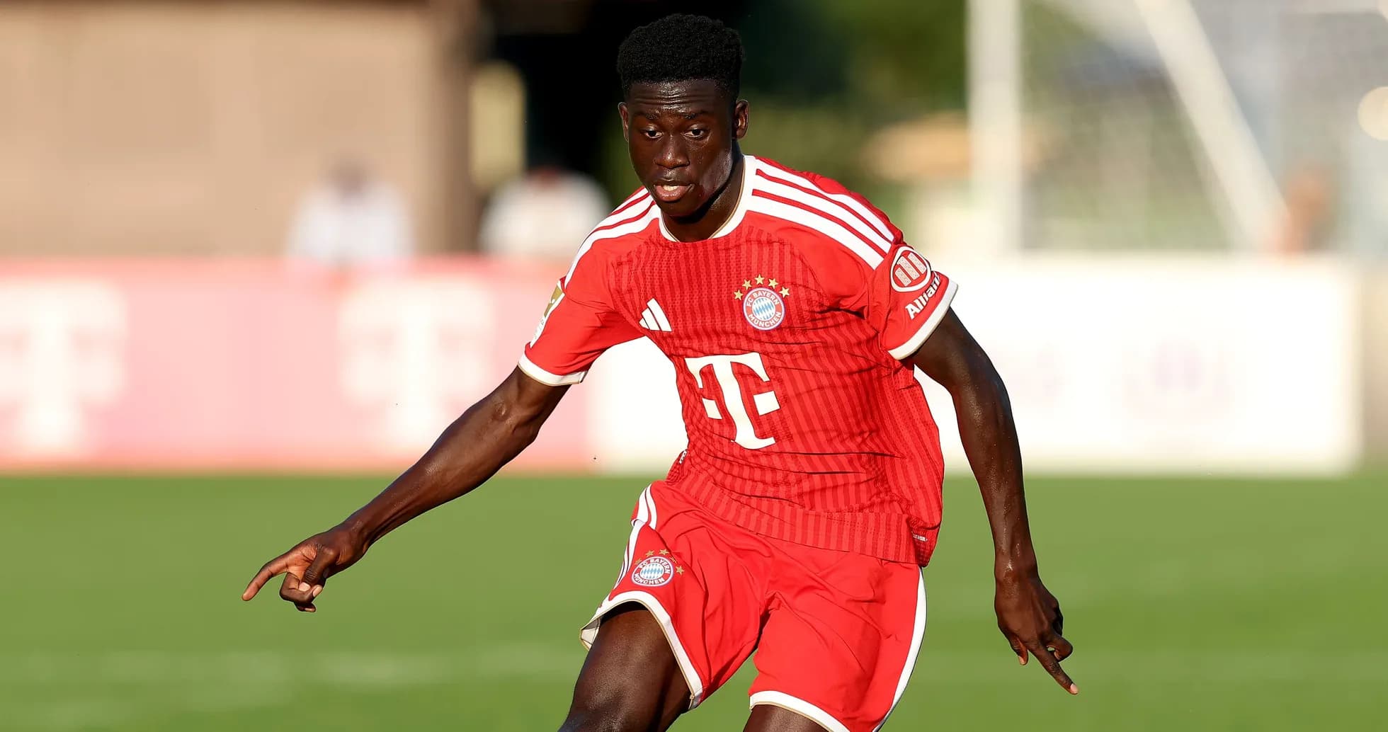 Player in red Bayern Munich kit running on pitch Player in red Bayern Munich kit running on pitch