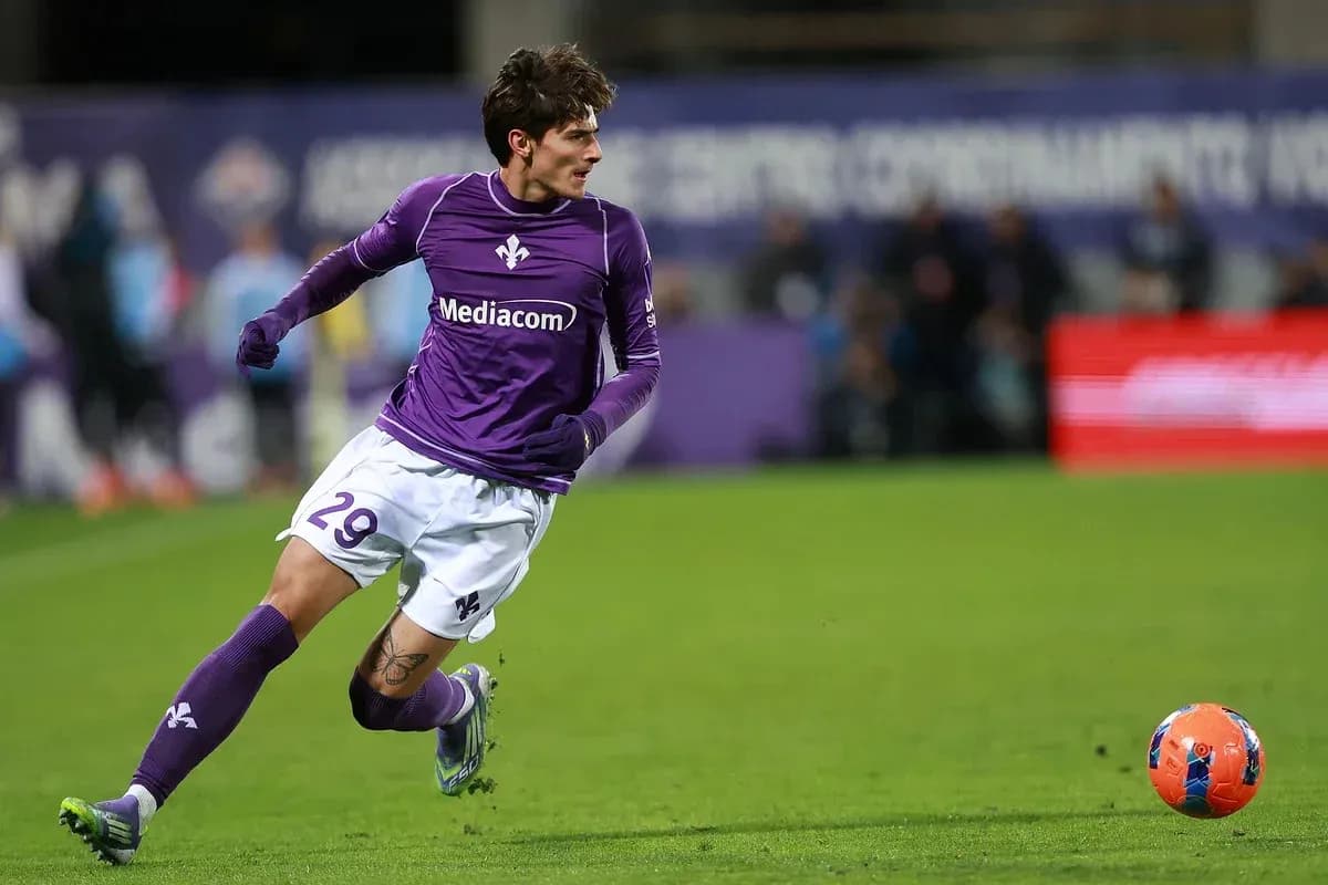 Player in purple jersey chasing the ball on field Player in purple jersey chasing the ball on field