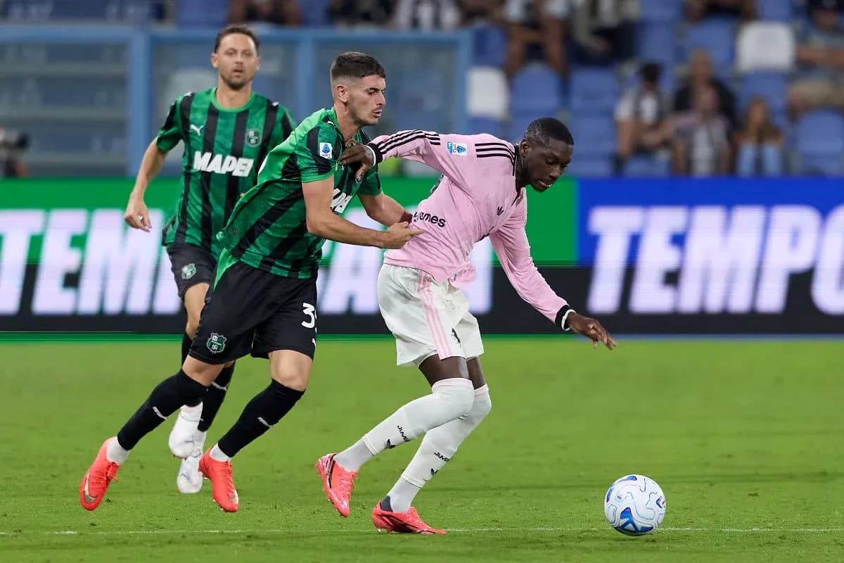 Sassuolo player tackling Juventus player during match Sassuolo player tackling Juventus player during match