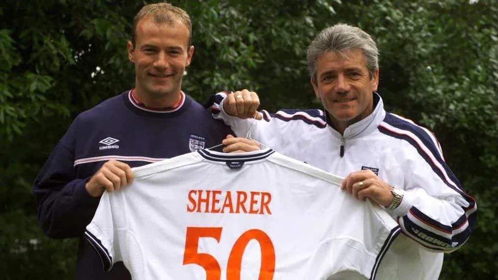 Two men holding a football shirt with 'SHEARER 50' Two men holding a football shirt with 'SHEARER 50'